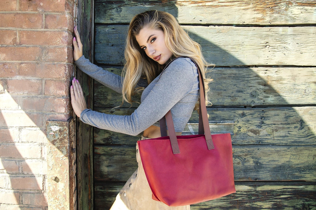 Red leather tote bag with bowl-shaped design and long handles for everyday use