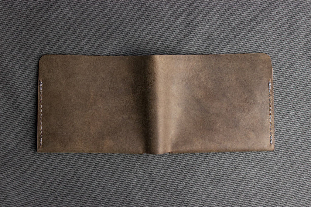 Buck Bifold Leather Wallet made of smooth cowhide with contrast stitching, 6 card slots, and full bill compartment, slim and stylish design.