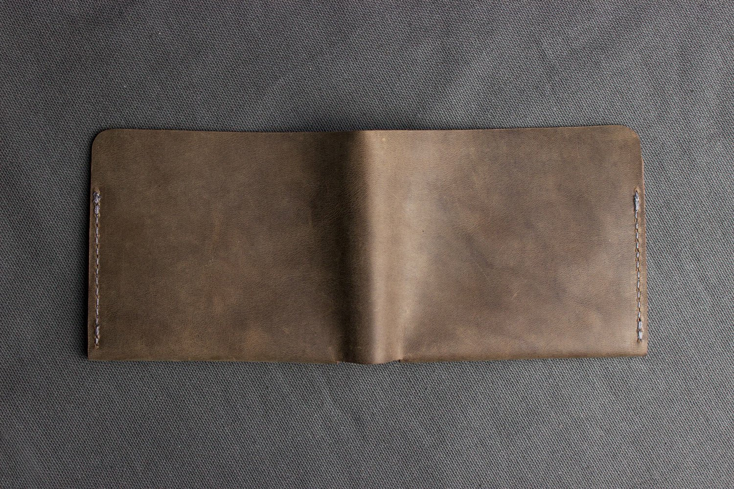 Buck Bifold Leather Wallet made of smooth cowhide with contrast stitching, 6 card slots, and full bill compartment, slim and stylish design.