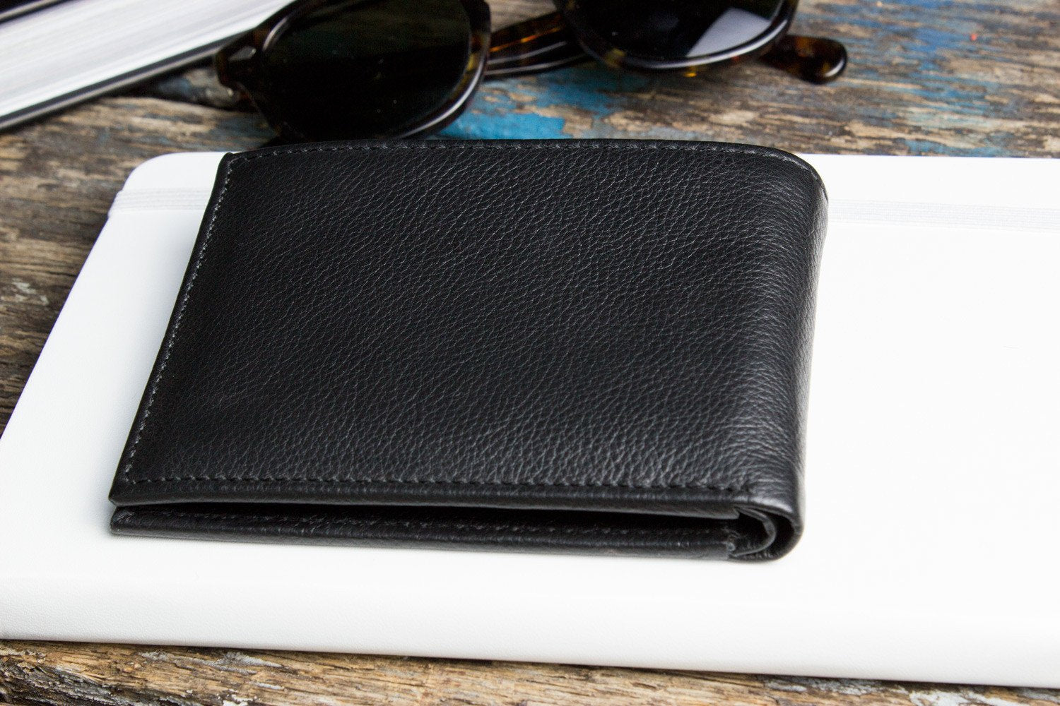 Traditional bifold wallet made of glove tanned cowhide leather with removable ID window and multiple card slots