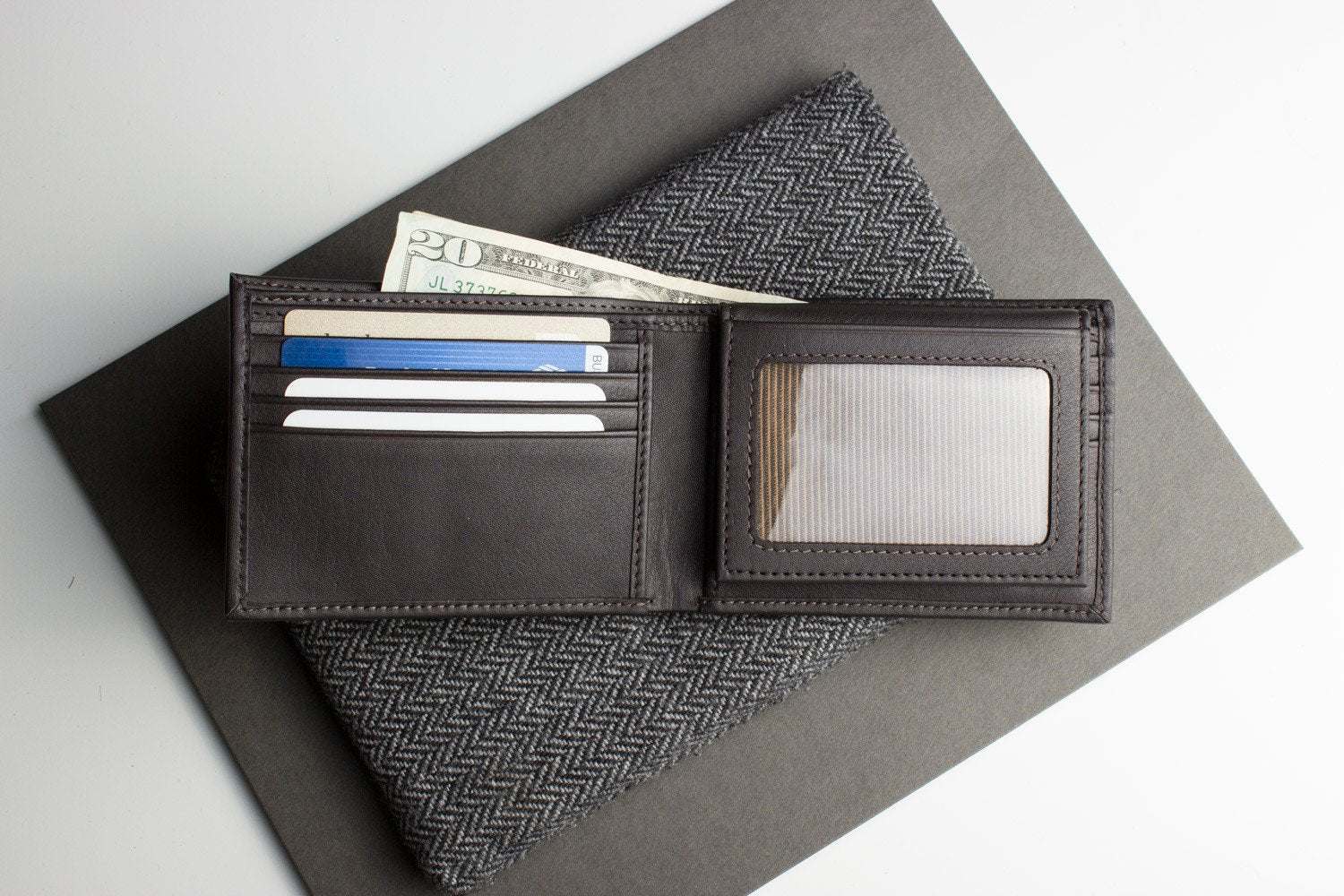 Traditional bifold wallet made from glove-tanned cowhide leather with ID window, card slots, and bill compartments