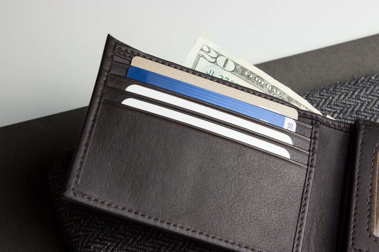 Traditional bifold wallet made of glove tanned cowhide leather with multiple card slots and removable ID window