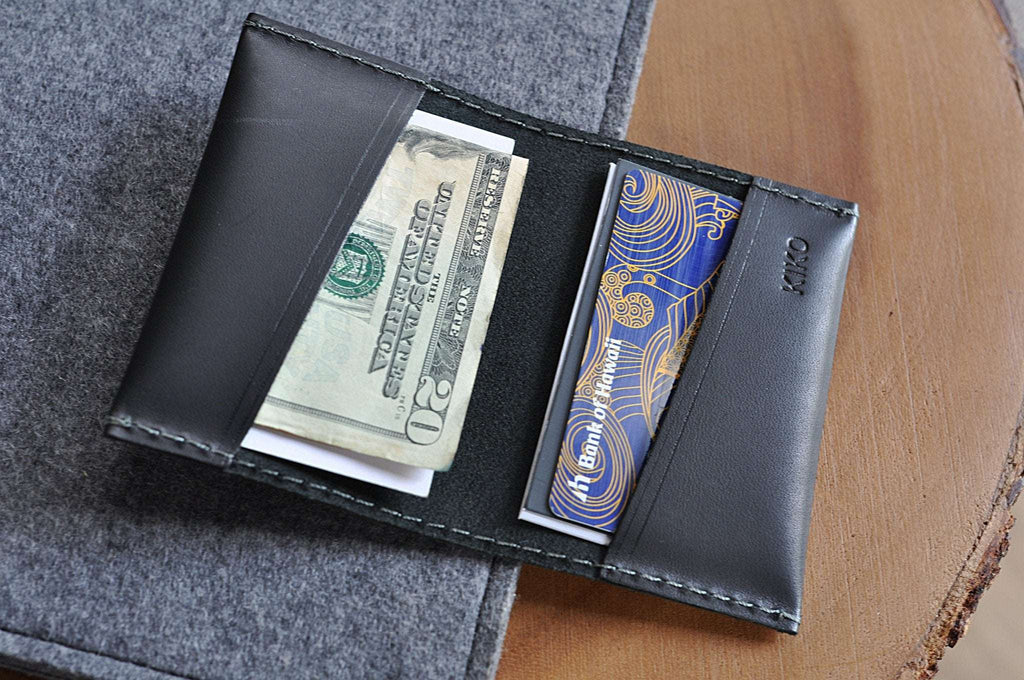 Black leather two fold card wallet with grey stitching and slim design