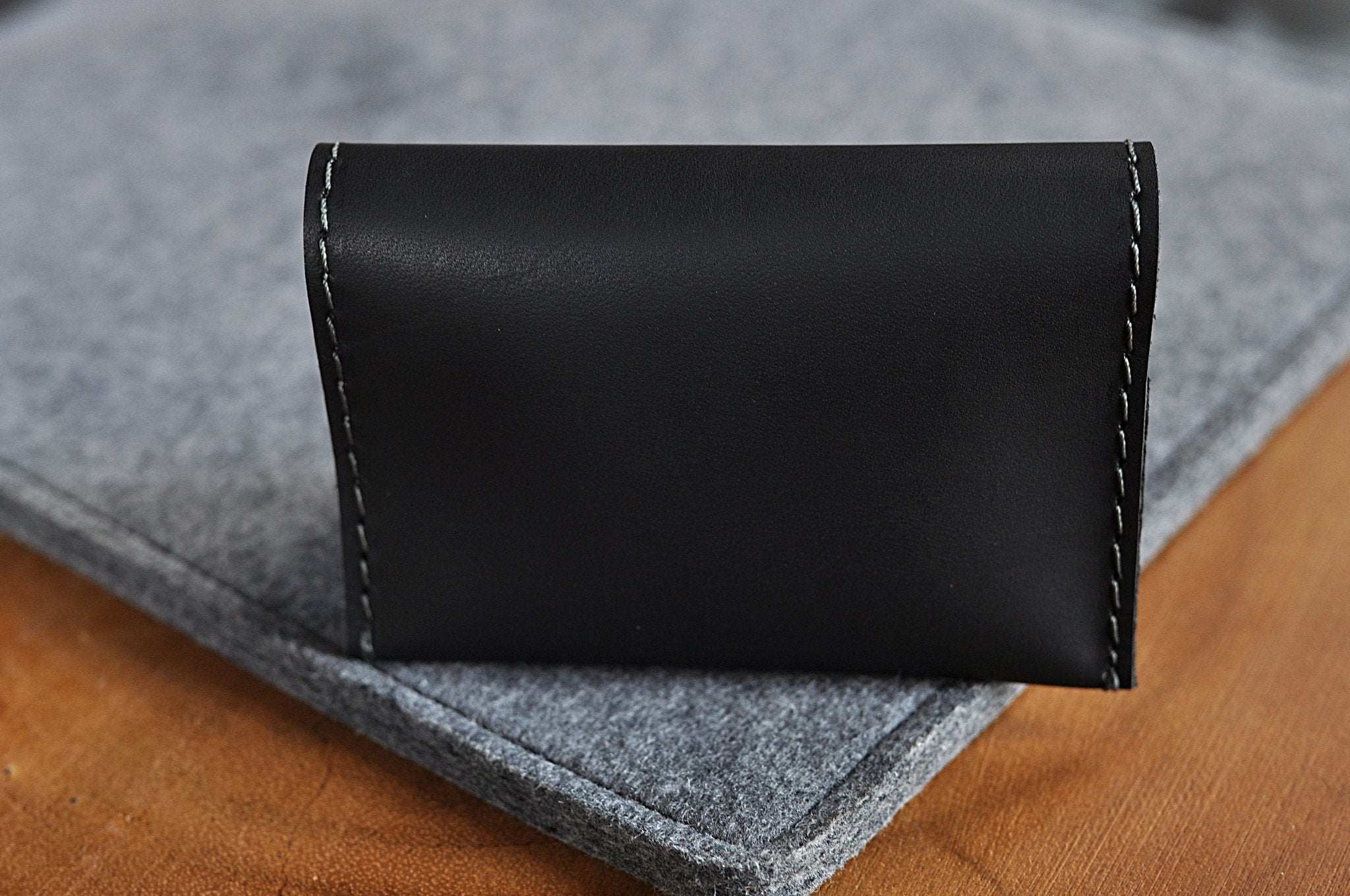 Black leather Two Fold Card Wallet with grey stitching and two card slots, slim minimalist design