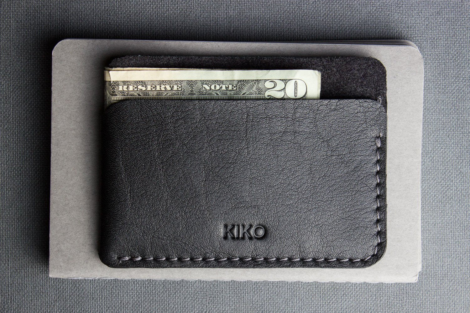 Minimalist top grain cowhide leather triple pocket card wallet with contrast stitching and three compartments for cards and cash
