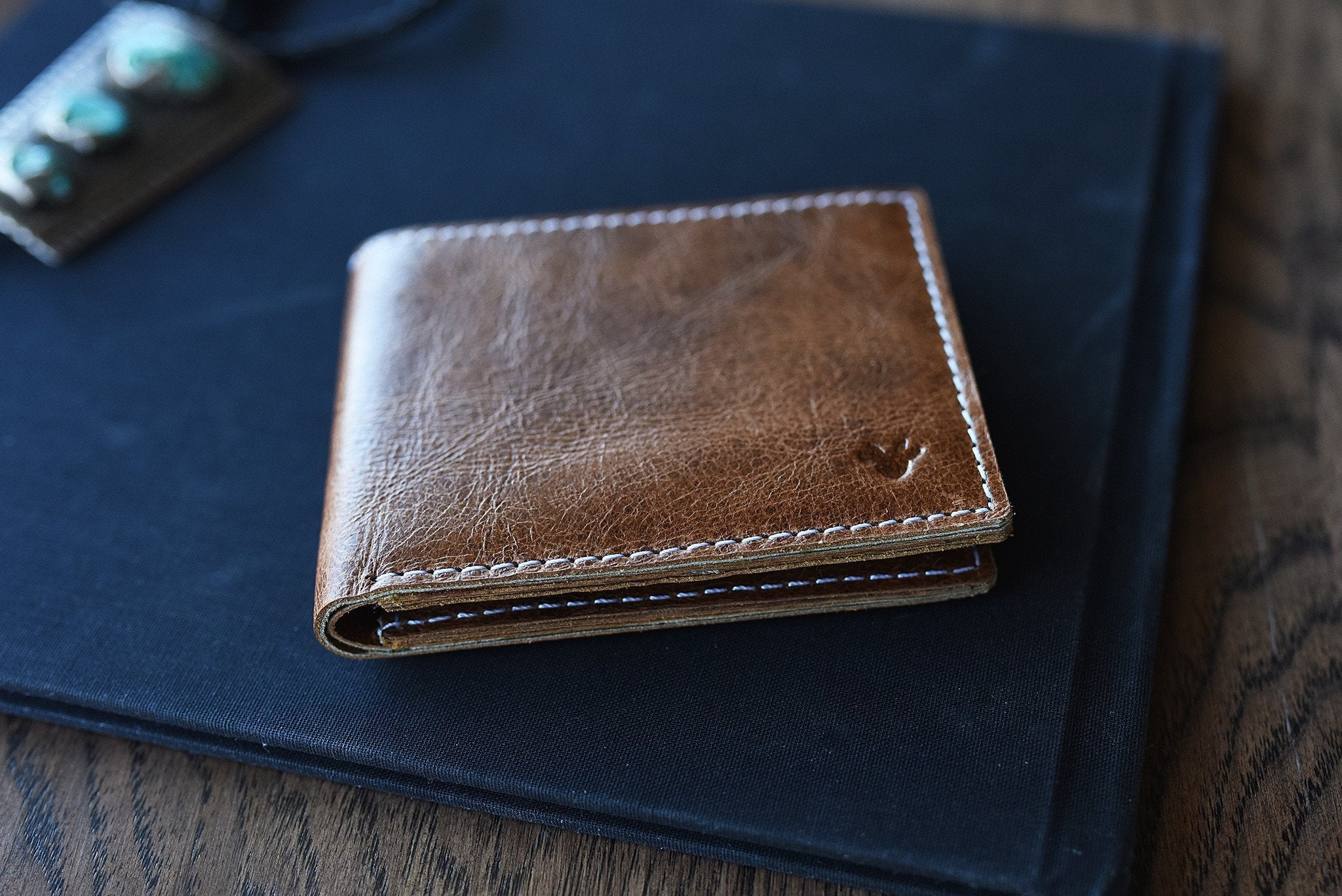 Kiko Leather X bifold wallet with white stitching and five card slots displaying natural leather texture