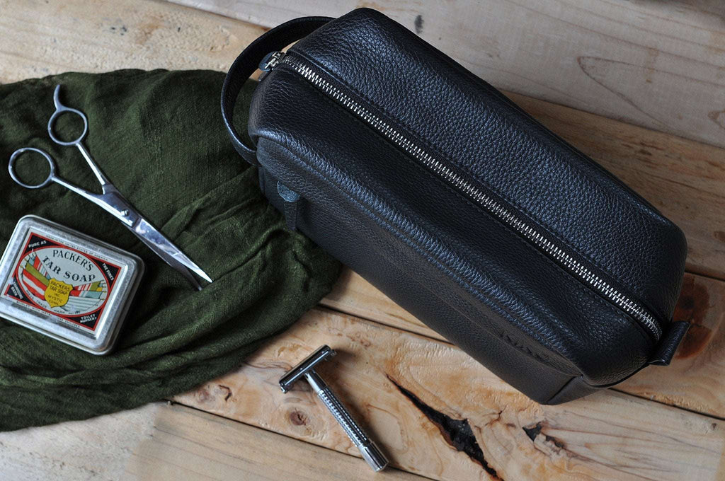 Premium black pebble leather travel kit with spacious interior, YKK zipper, and side handle for organized grooming essentials