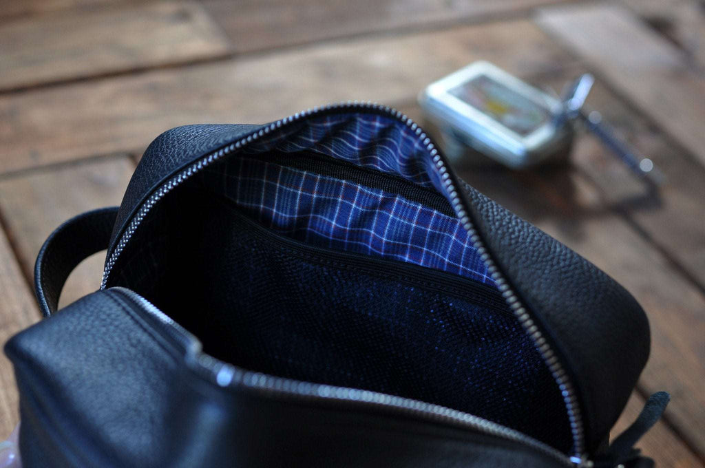 Premium black pebble leather travel kit with zipped side pouch and carrying handle for toiletries organization