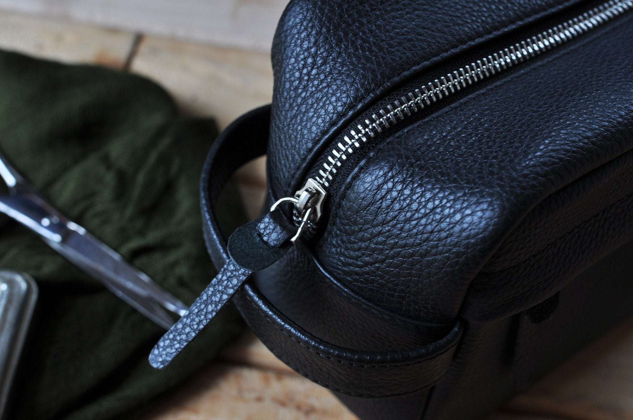 Premium black pebble leather travel kit with YKK zipper and side handle for organized toiletries
