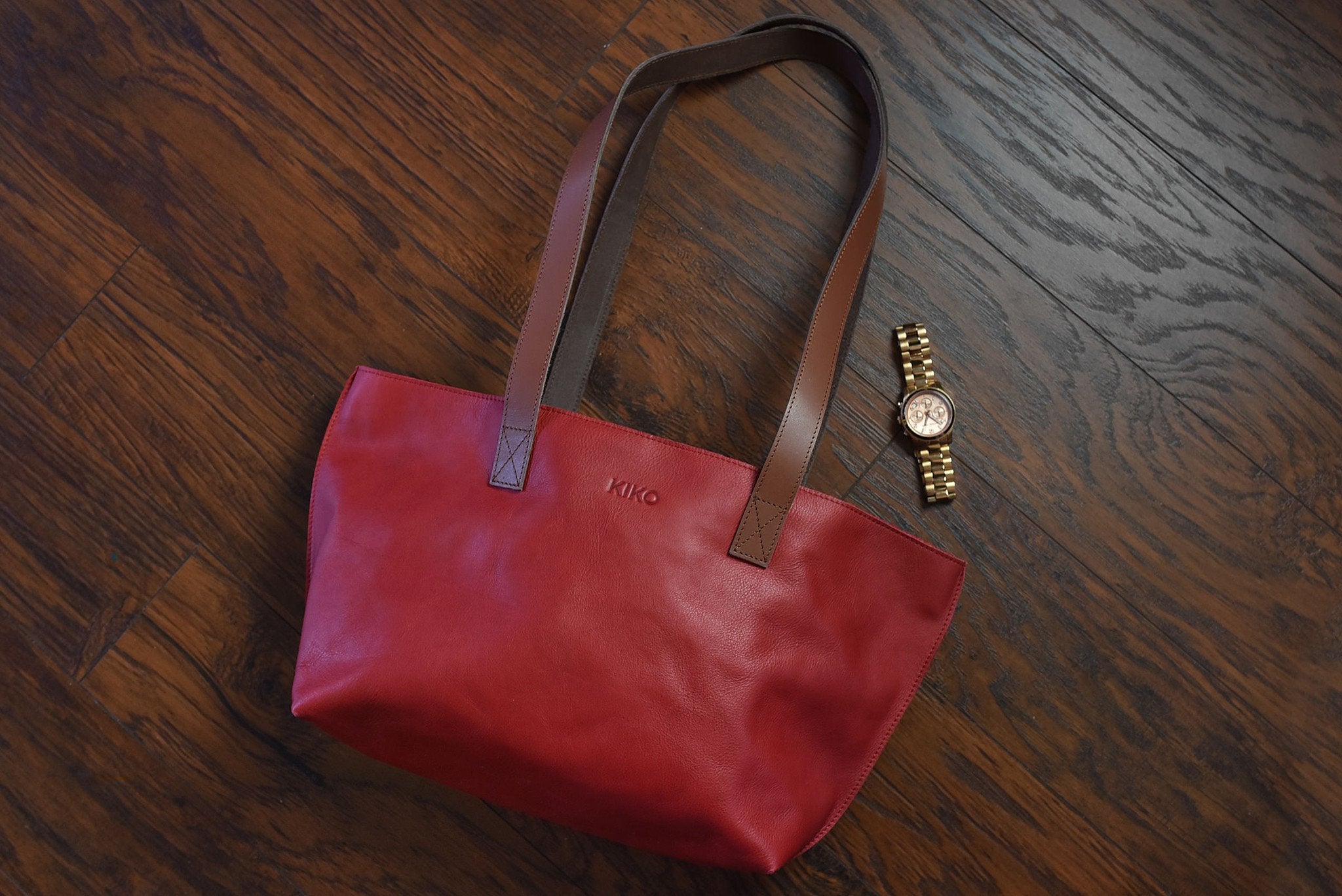 Red tote bag made of genuine leather with bowl-shaped design and shoulder handles