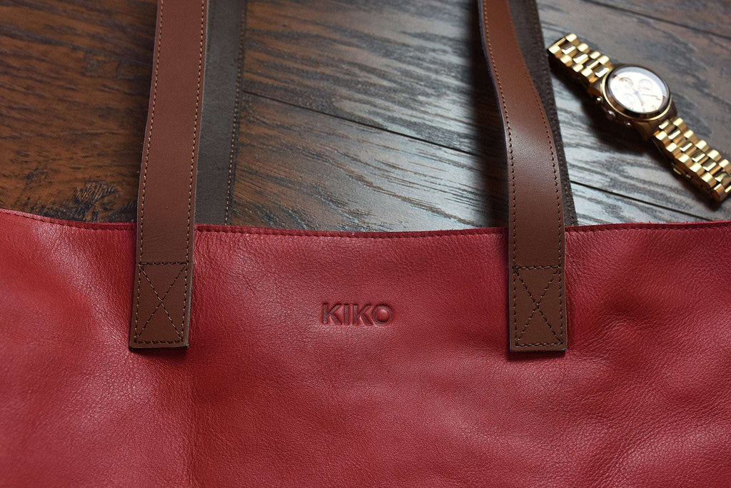 Red leather tote bag with bowl-shaped silhouette and long handles for shoulder carrying