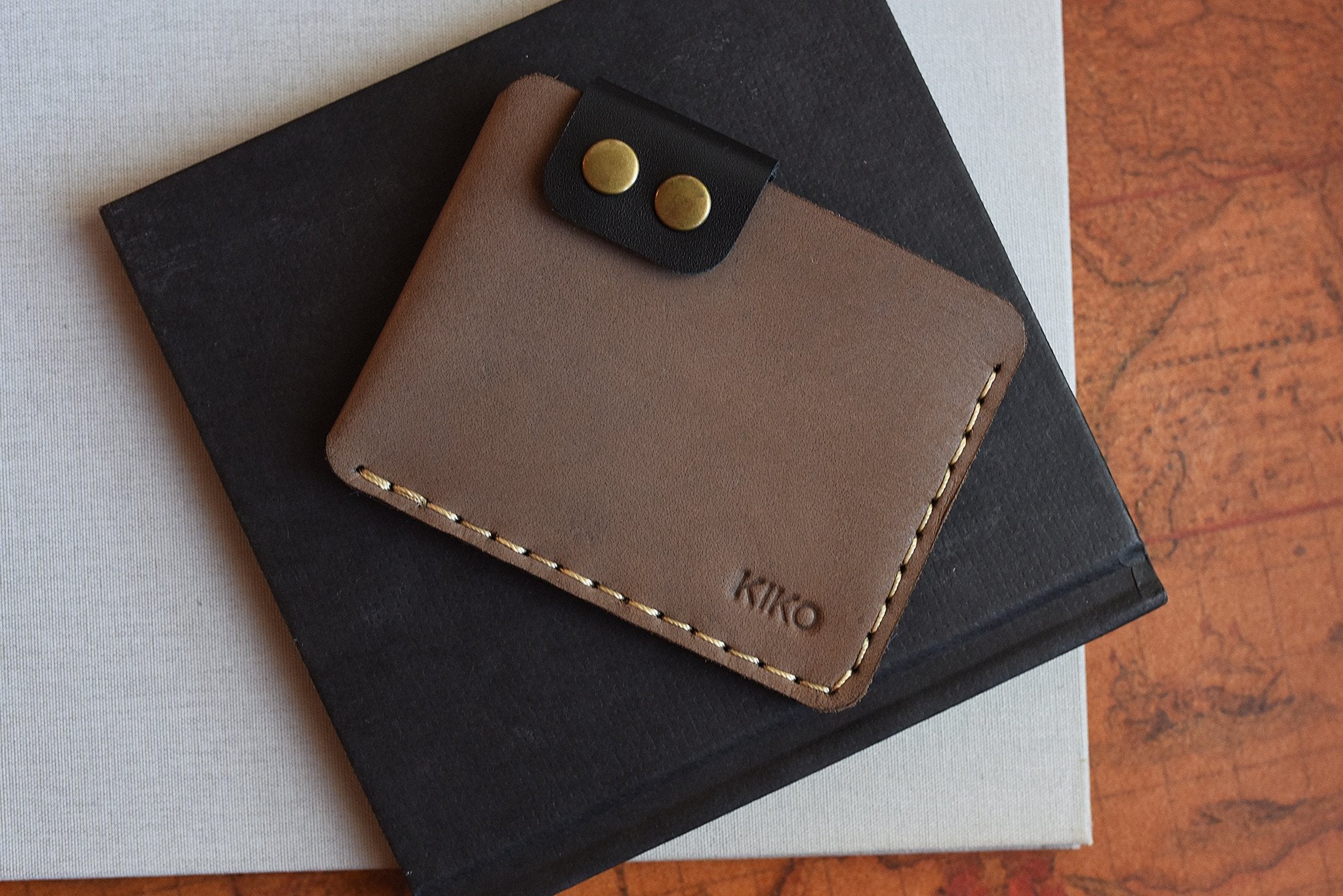 Slim Kiko Card Wallet in leather with brass buttons and secure flap closure