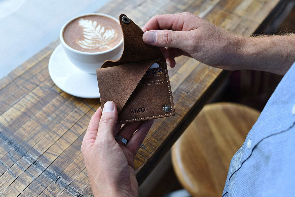Compact Kiko Wing Fold Wallet with geometric leather design, white stitching, and secure button closures for organized card and cash storage