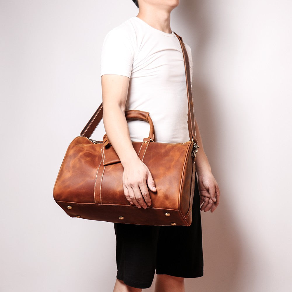 The Brandt Weekender small black leather duffle bag with sturdy handles and adjustable strap