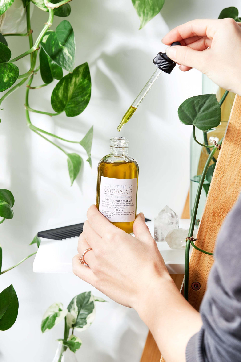 Bottle of organic scalp treatment oil by Butter Me Up Organics for hair growth with natural herbs and oils