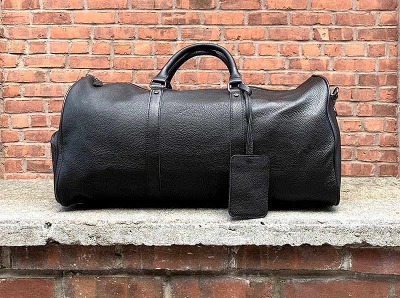 Black Endre Weekender Leather Duffle Bag with premium leather, multiple compartments, and adjustable shoulder strap for travel and work