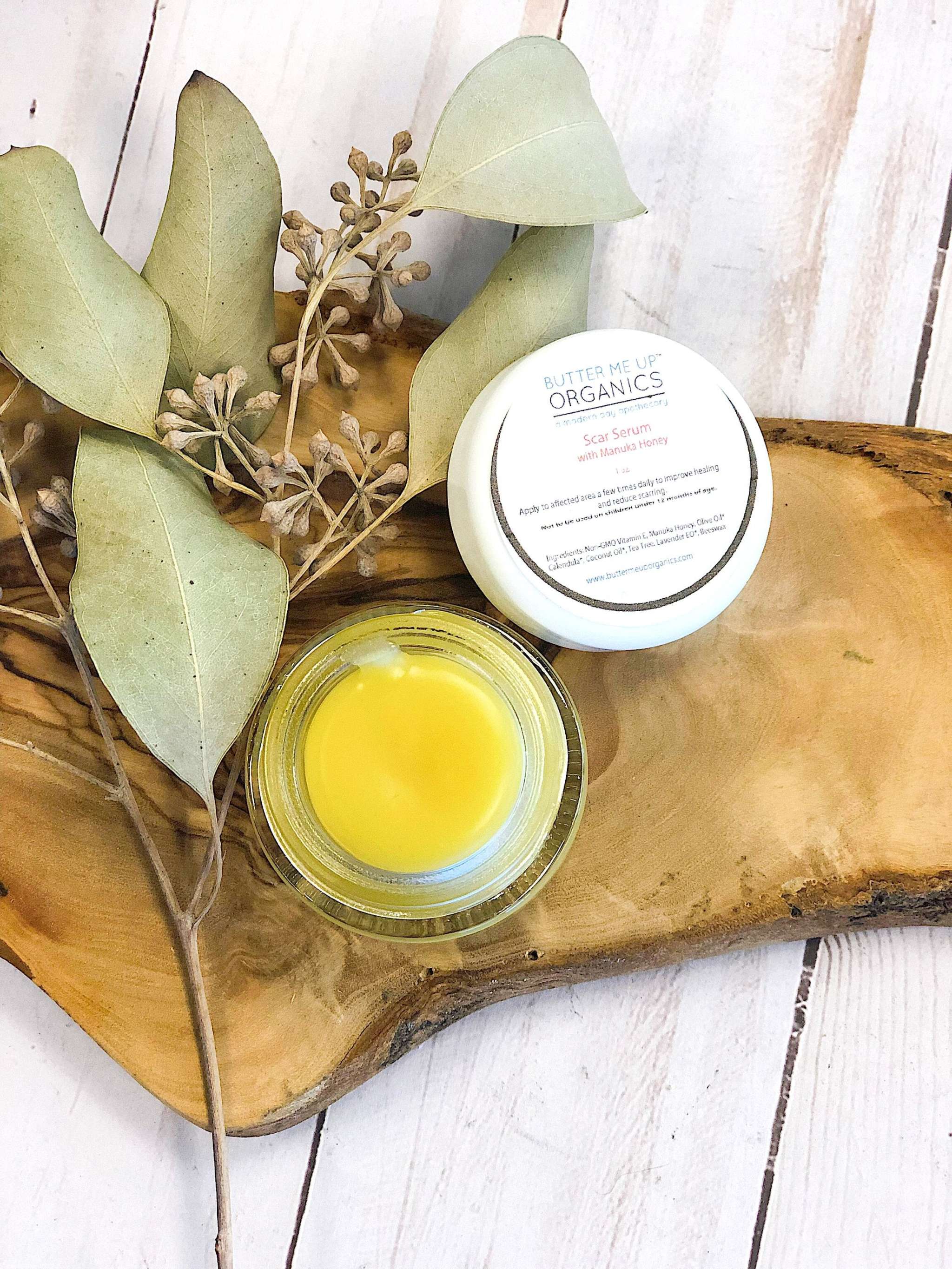 Organic scar healing serum bottle with natural ingredients like Manuka honey, Vitamin E, and tea tree oil