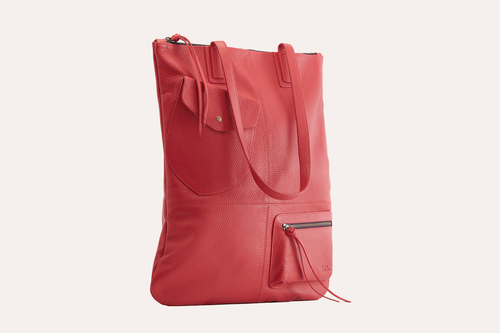 Fold n Hold Tote in cowhide leather with large interior and 2 exterior pockets, plaid lining, and zipper tassels.