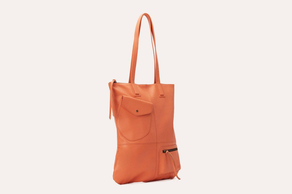 Fold n Hold Tote made of cowhide leather with large interior and two exterior pockets, soft plaid lining, and zipper tassels.