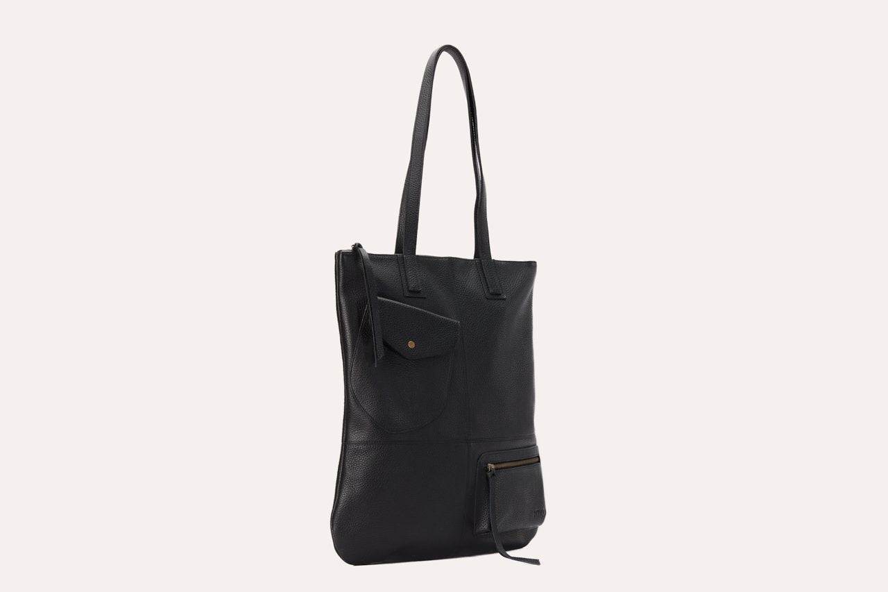 Fold n Hold Tote in cowhide leather with large interior and two exterior pockets, plaid lining, and zipper tassels