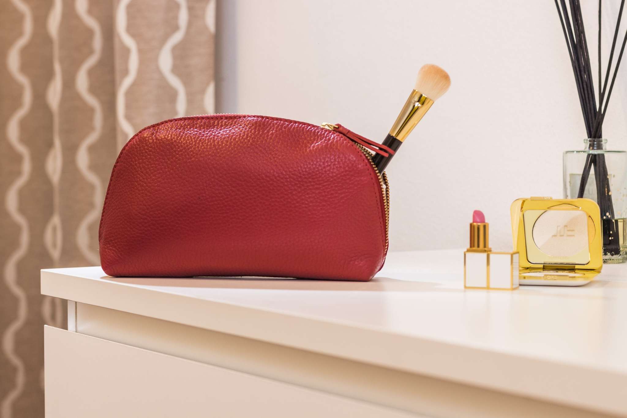 Medium travel case made of genuine pebble leather with zipper closure and internal pocket