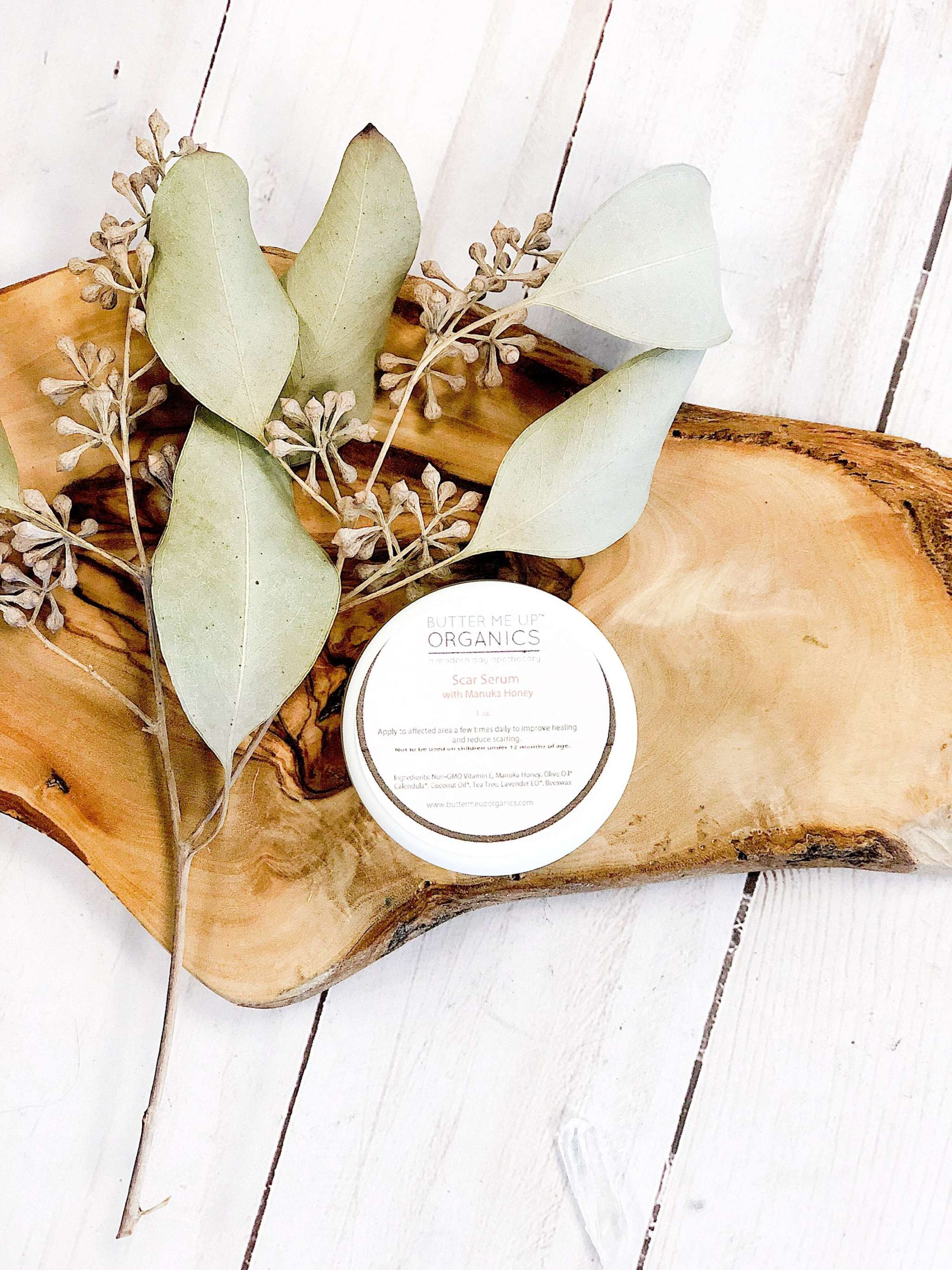 Bottle of organic scar healing serum by Butter Me Up with natural ingredients displayed alongside product label