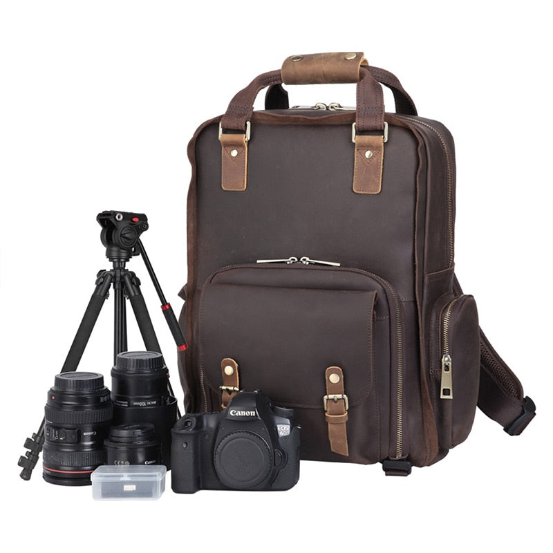Large leather camera bag backpack in rugged full-grain leather with padded straps and multiple compartments for cameras and laptop