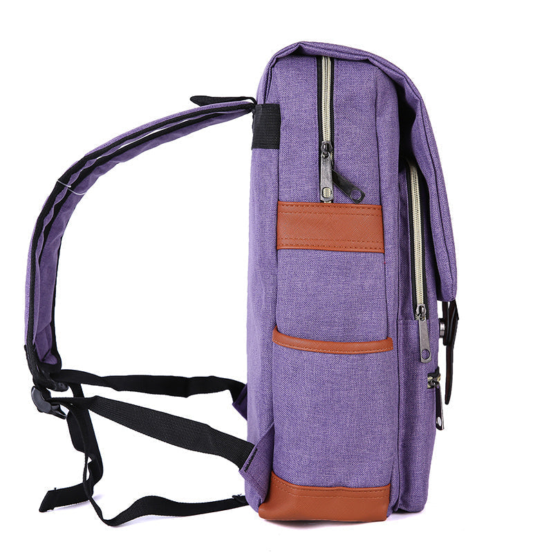 Vintage Laptop Backpack in purple woven fabric with brown faux-leather trim, zippered side pockets, and adjustable black straps.