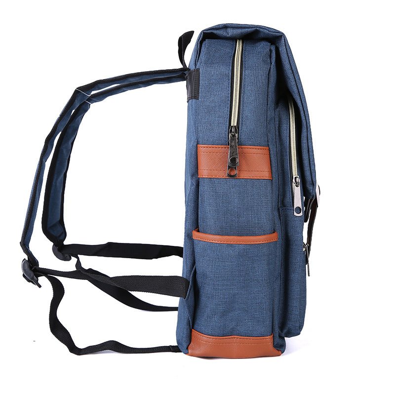 Slim Backpack in textured navy fabric with brown trim, featuring a tall zippered profile, front pockets, and adjustable black straps.