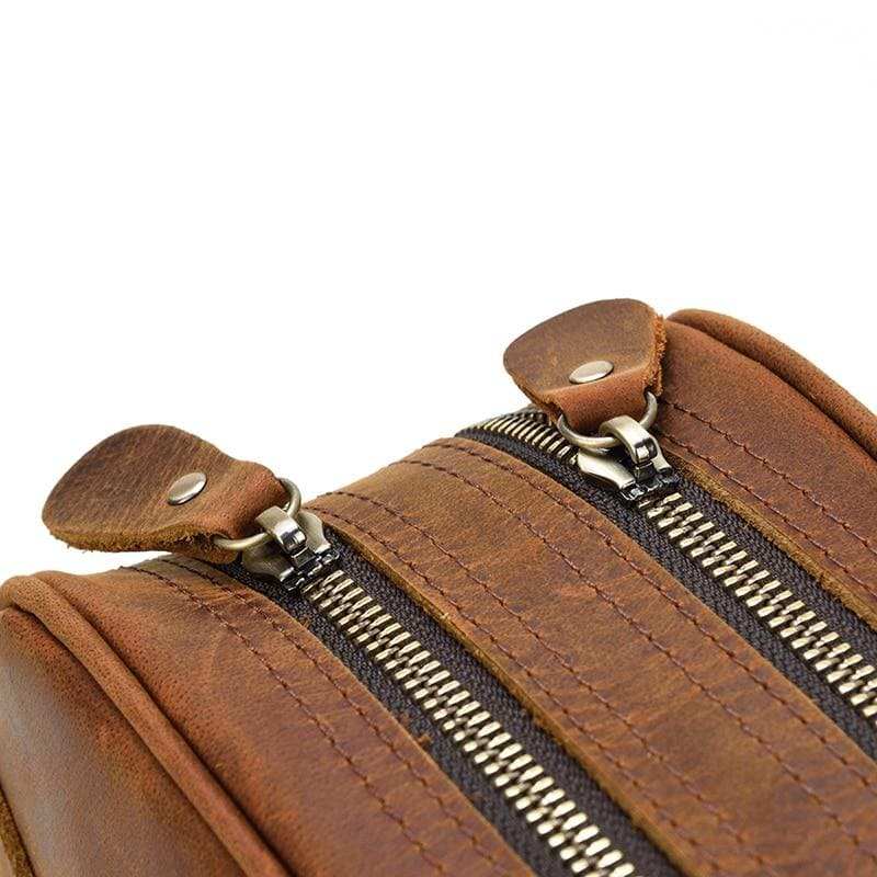 Genuine leather travel toiletry bag in brown crazy horse leather with multiple zippered compartments and compact design for organized travel essentials