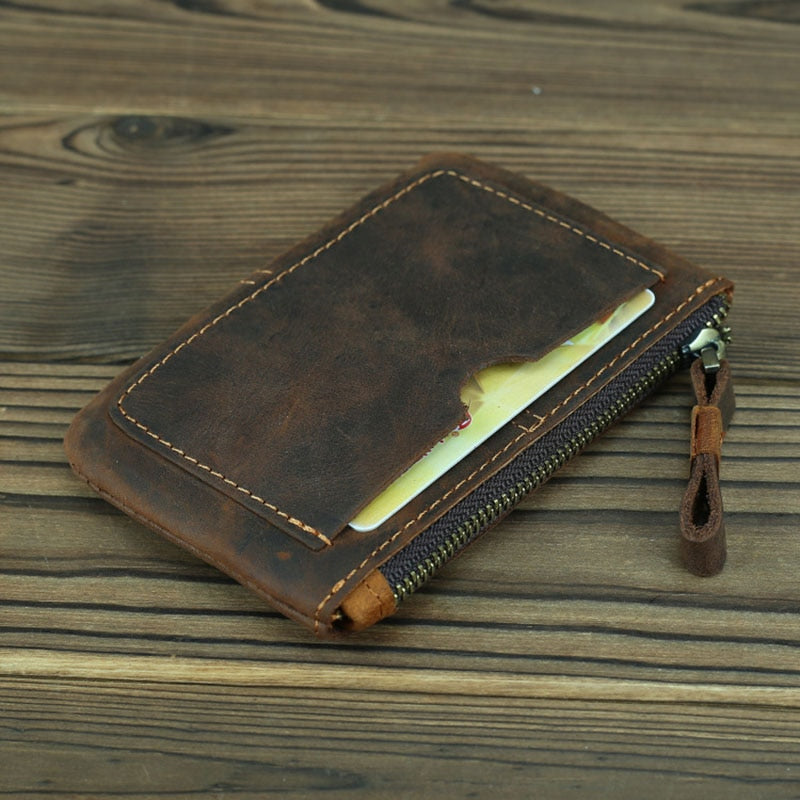 Cael leather coin purse handmade from full-grain crazy horse leather with YKK zipper and key ring attachment on wooden surface