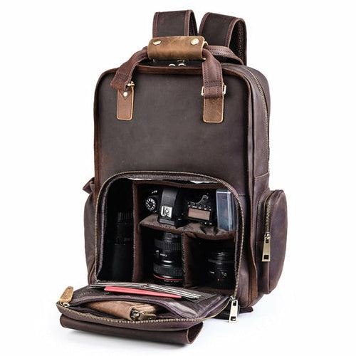 Large leather camera bag backpack made from full-grain crazy horse leather with padded straps and multiple compartments for camera gear and laptop.