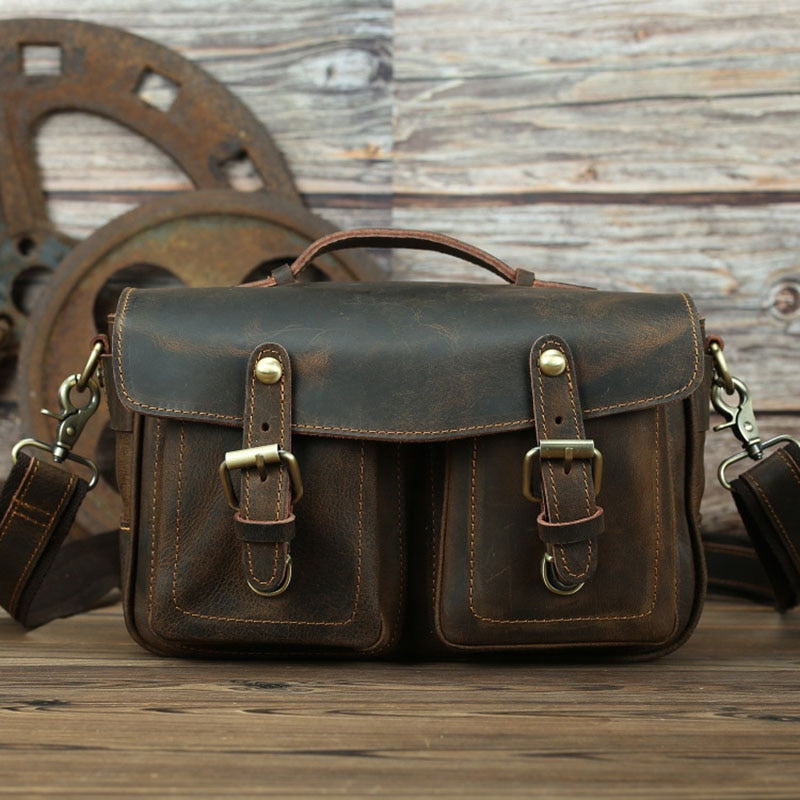 The Faust Leather Crossbody Messenger Bag in full-grain crazy horse leather, featuring adjustable shoulder strap and spacious interior for camera gear.