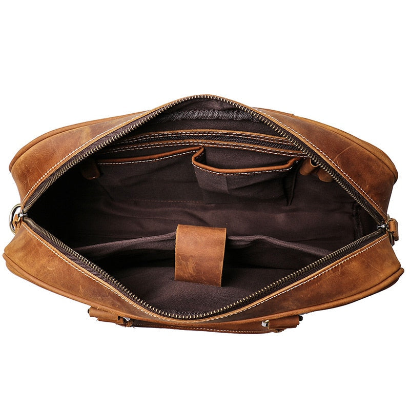 Vintage leather briefcase Bjorn made of premium crazy horse leather with adjustable shoulder strap and spacious compartments for laptops up to 14 inches.