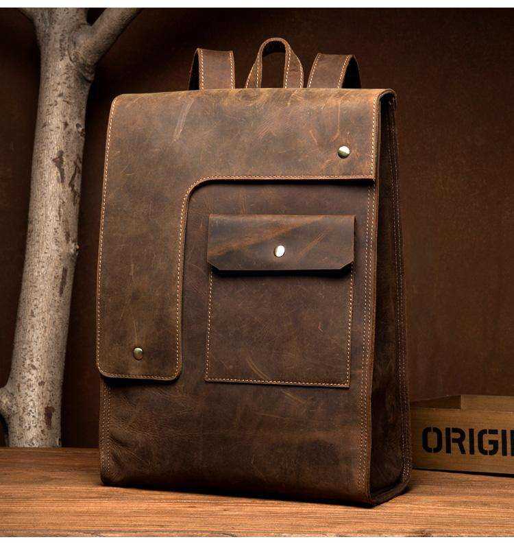 Vintage Leather Backpack in brown distressed leather, featuring a flap closure, front pocket and rivet details